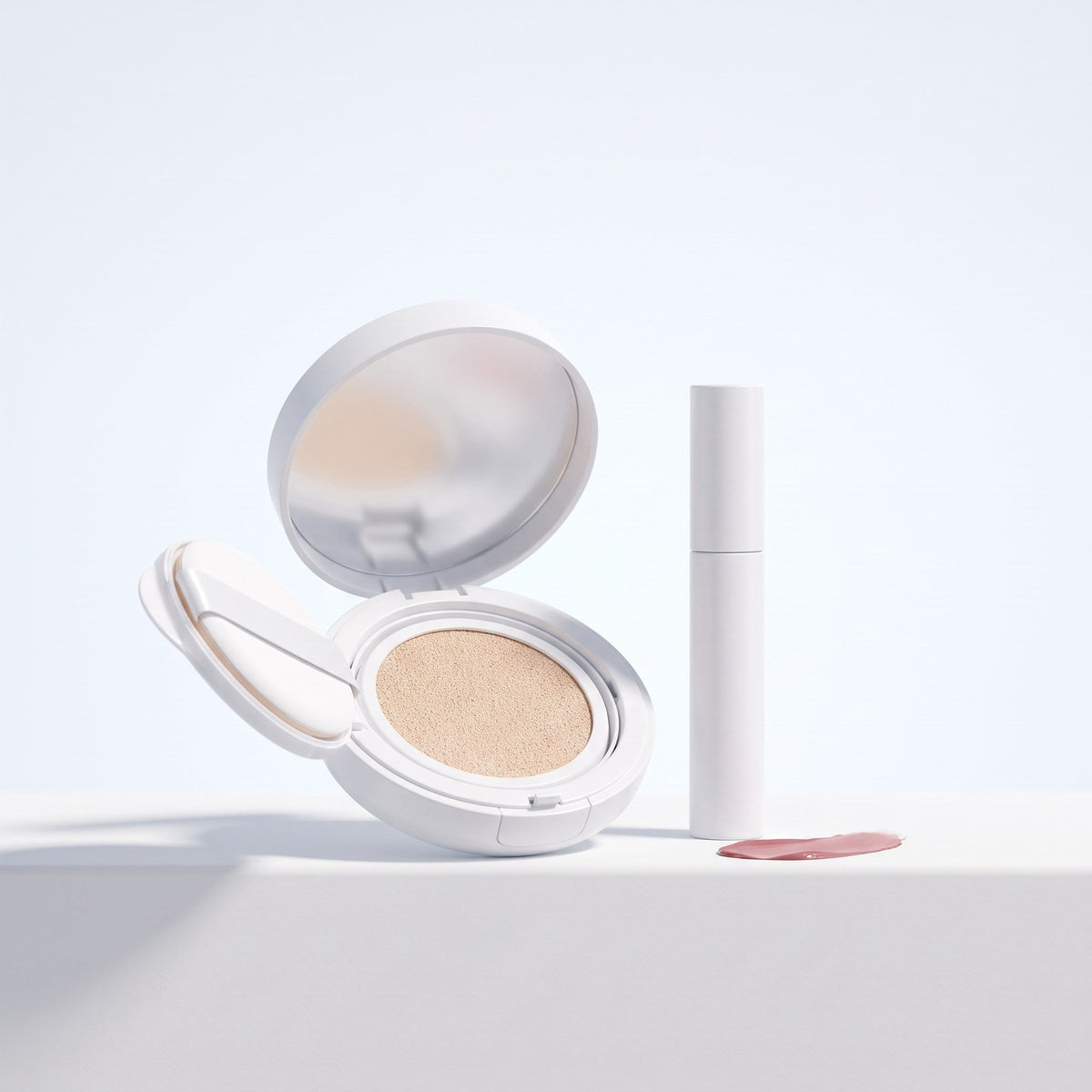Open cushion compact, lip tint tube and a blush swatch