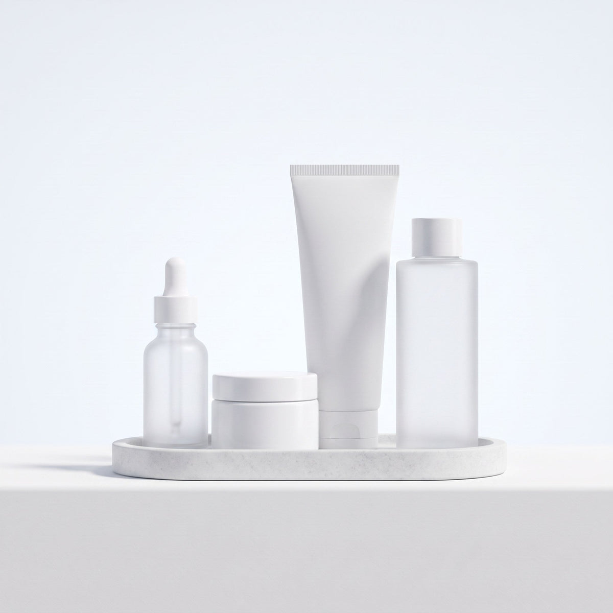 Four unlabeled skincare products on a stone tray