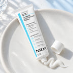 Textura de la crema NIDA junto al tubo de 100 ml.