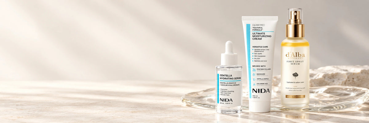 Outglow beauty edit — NIDA Centella Hydrating Serum, NIDA Moisturizing Cream and d’Alba First Spray Serum on pale limestone and glass